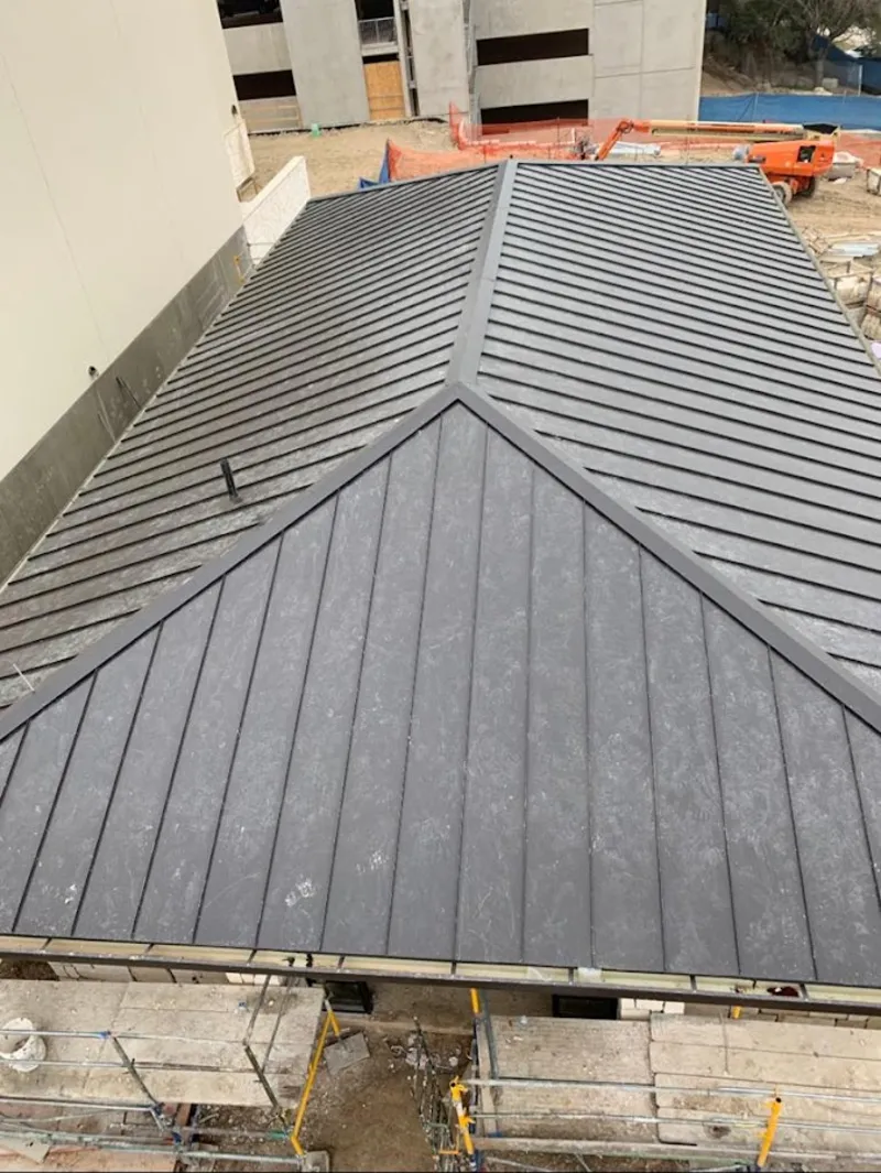 Commercial metal roof construction with crane equipment in Irvington